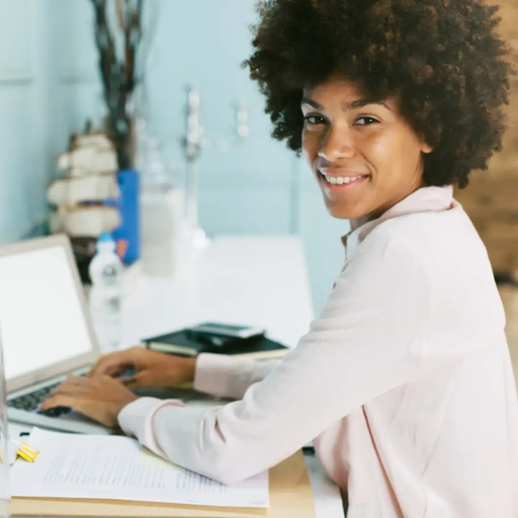 Profesional de negocios sonriendo mientras observa un panel de automatización de LinkedIn con métricas positivas.